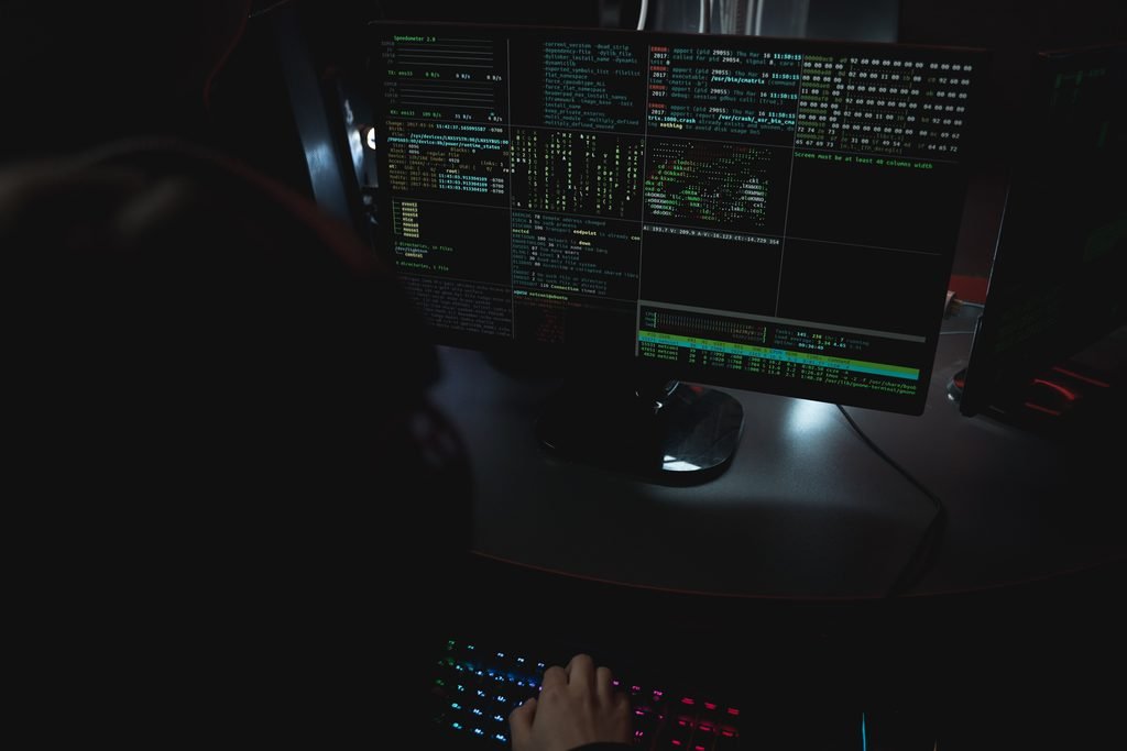 Cybersecurity analyst monitoring AI system activity on multiple screens