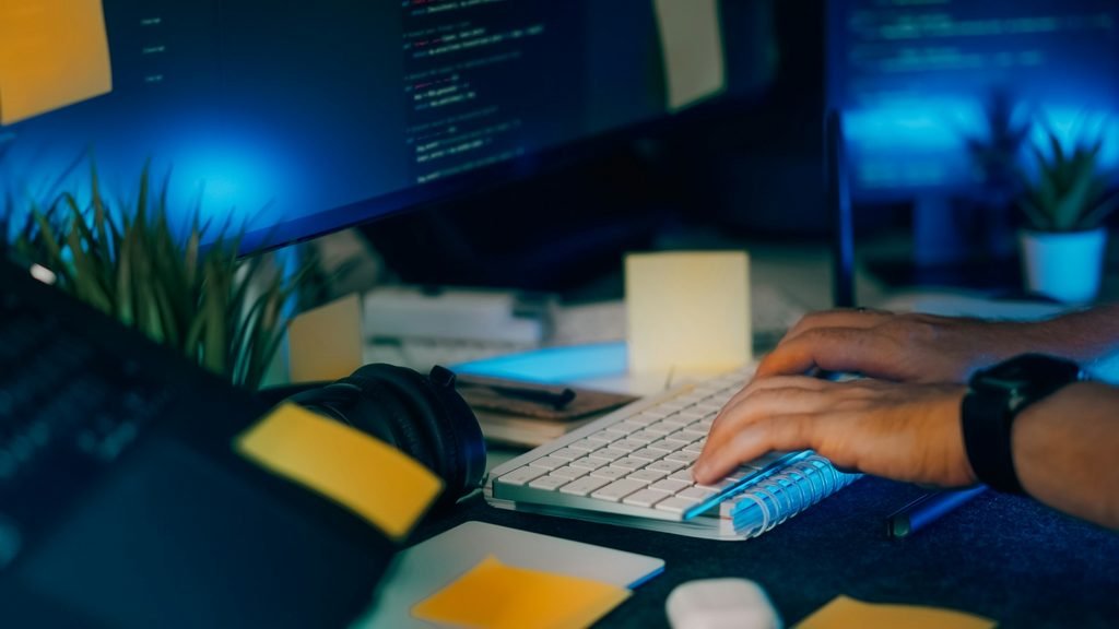 Developer testing Claude Opus 5.5 coding workflows at a multi-monitor workstation